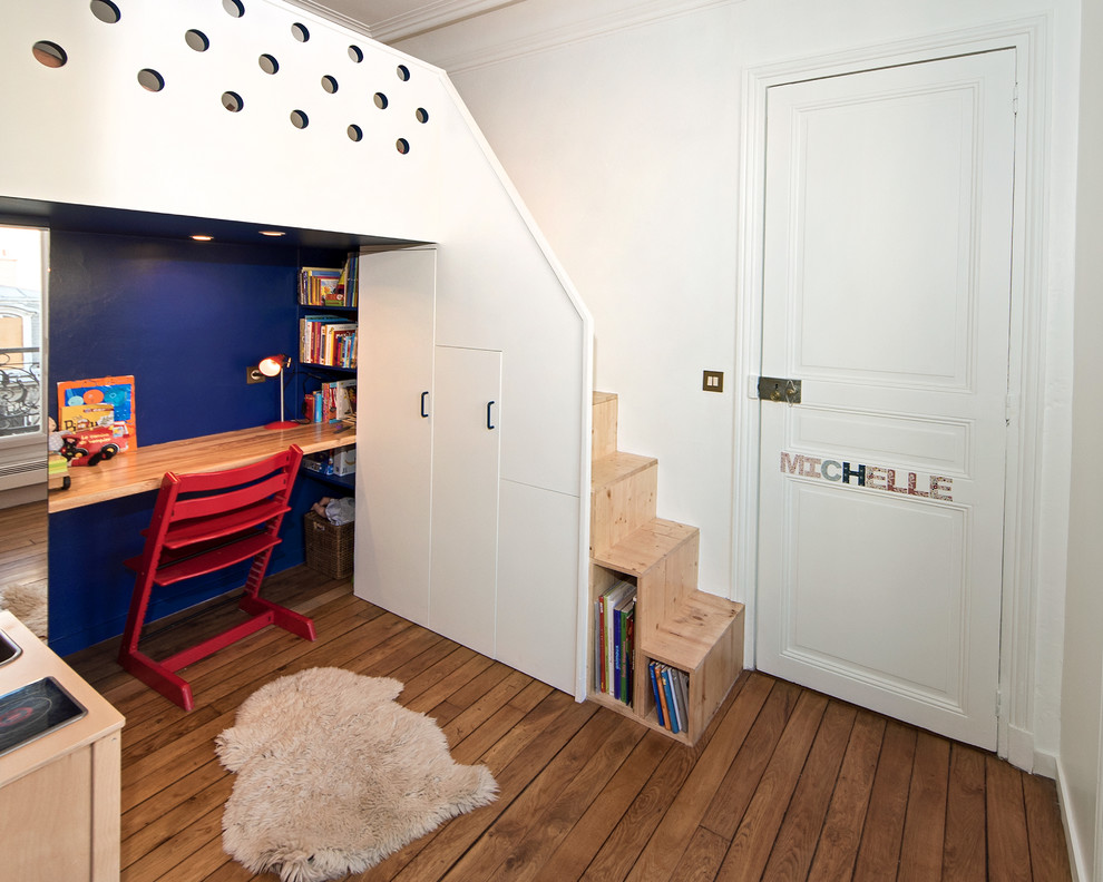 Cette image montre une chambre de fille de 4 à 10 ans traditionnelle de taille moyenne avec un bureau, un mur bleu, parquet foncé et un sol marron.