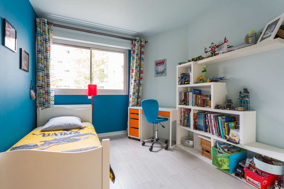 Modelo de habitación de niño de 4 a 10 años actual de tamaño medio con paredes azules y suelo de madera clara