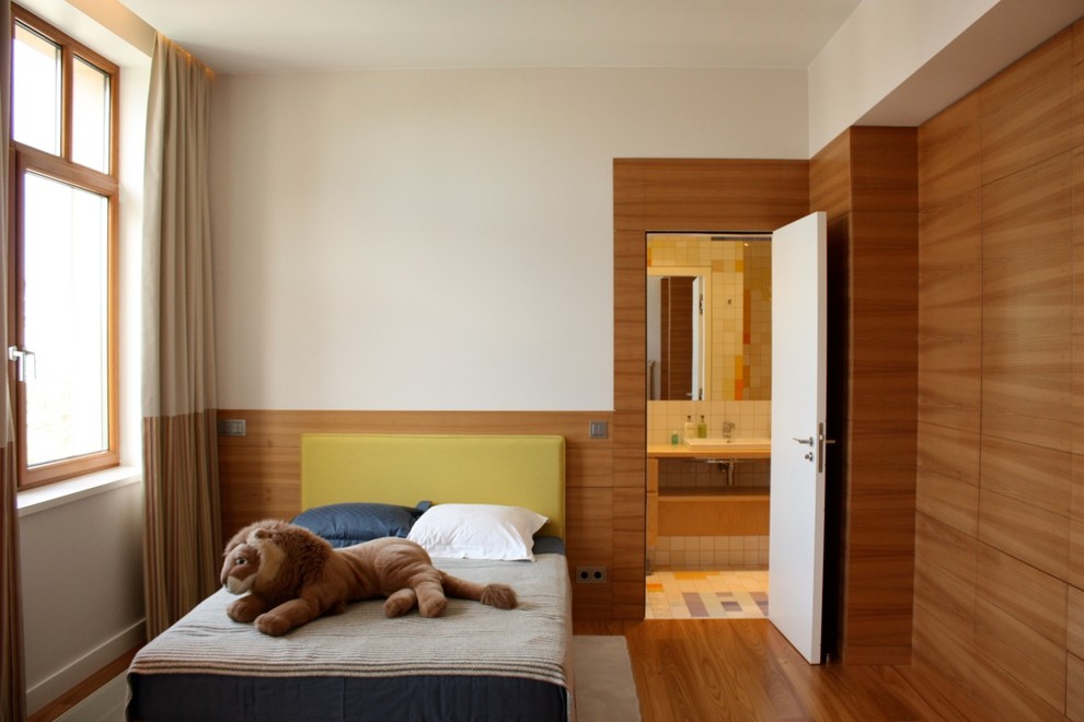 Diseño de dormitorio infantil minimalista de tamaño medio con paredes blancas y suelo de madera en tonos medios