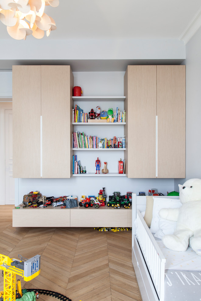 Réalisation d'une chambre d'enfant design de taille moyenne avec un mur gris, un sol en bois brun et un sol marron.
