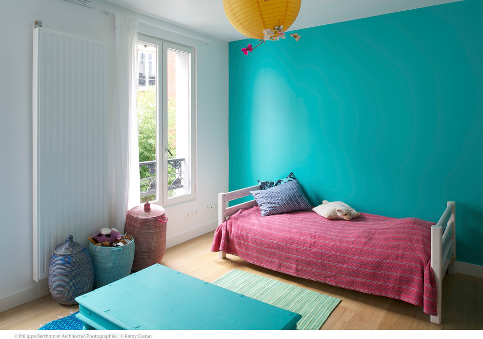 Idéer för ett mellanstort modernt könsneutralt barnrum kombinerat med sovrum och för 4-10-åringar, med blå väggar och ljust trägolv