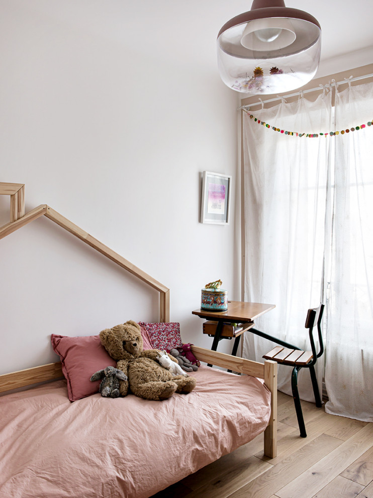Inspiration för mellanstora moderna barnrum kombinerat med sovrum och för 4-10-åringar, med rosa väggar och ljust trägolv