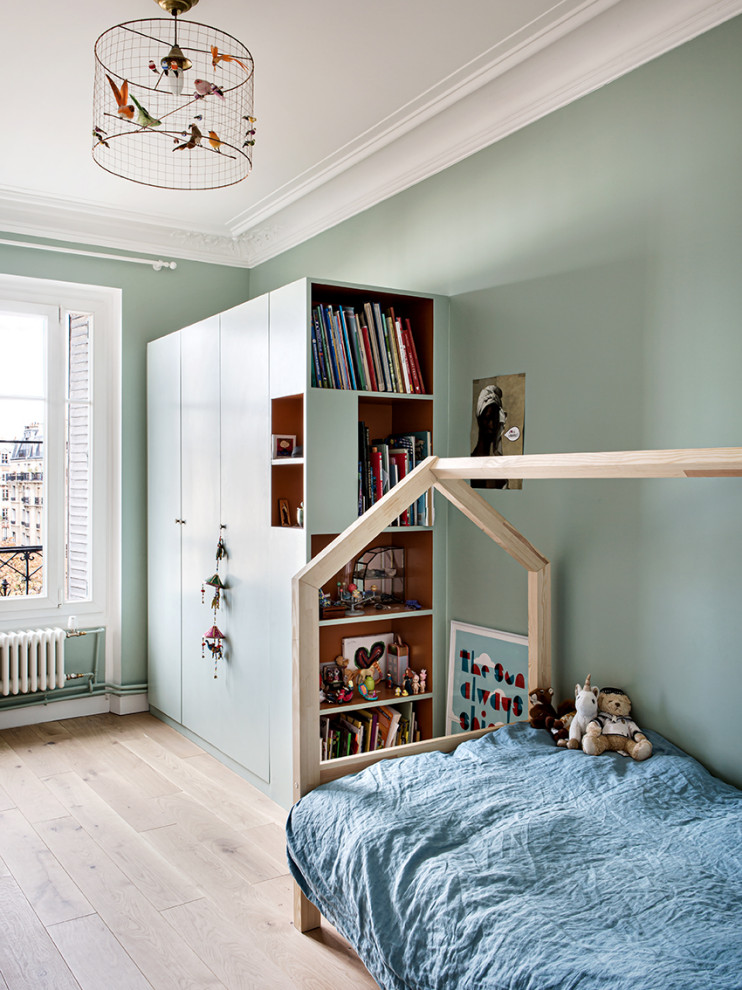 Inspiration för ett mellanstort funkis barnrum kombinerat med sovrum och för 4-10-åringar, med blå väggar och ljust trägolv