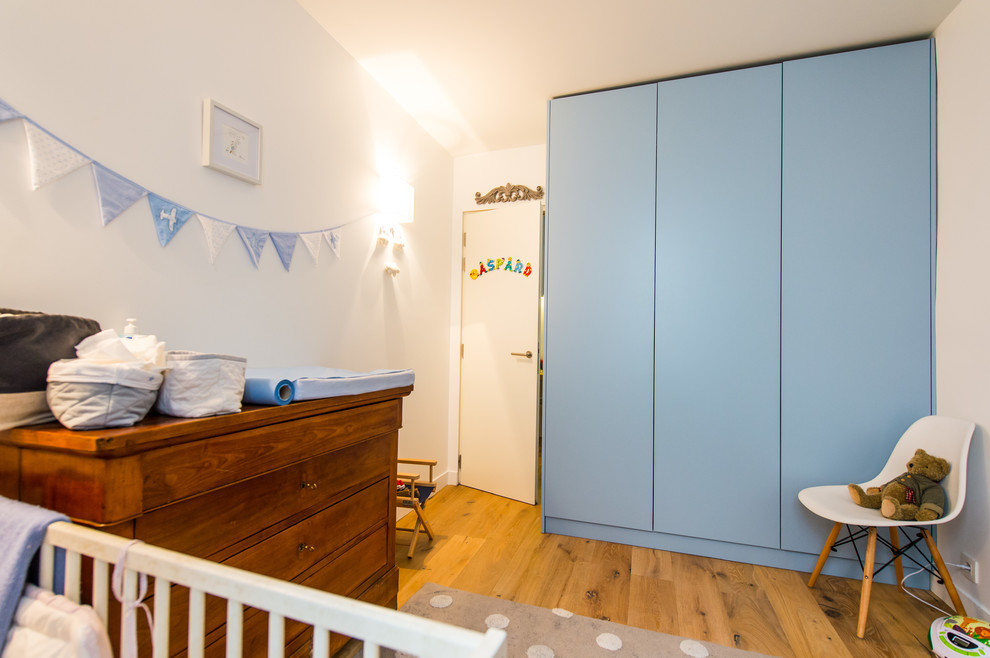 Kids' room - small contemporary boy light wood floor and brown floor kids' room idea in Paris with blue walls