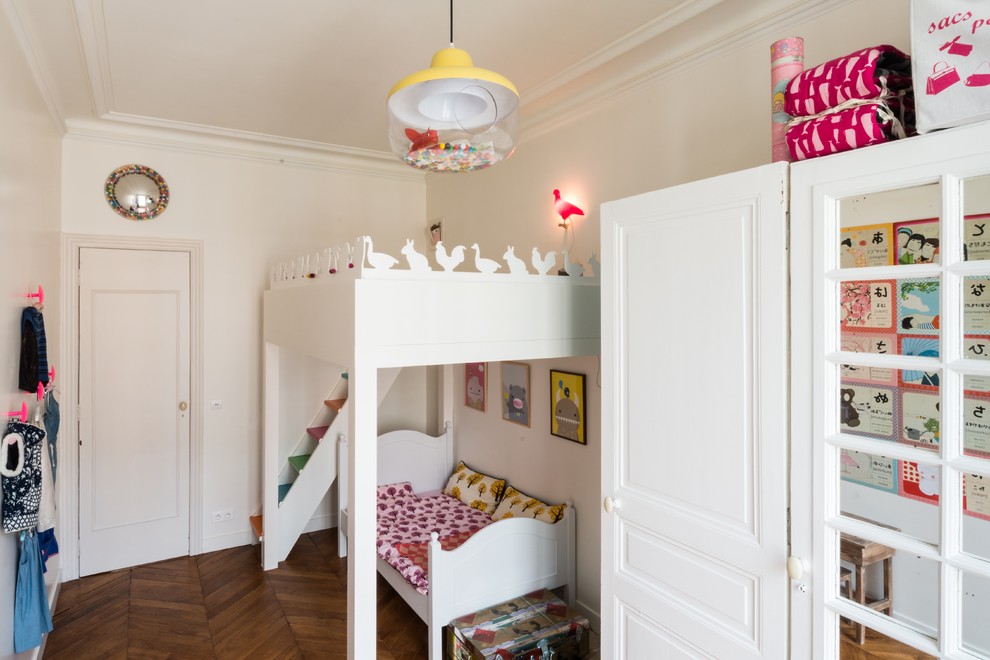 Réalisation d'une chambre d'enfant de 1 à 3 ans bohème avec un mur blanc, un sol en bois brun et un lit superposé.