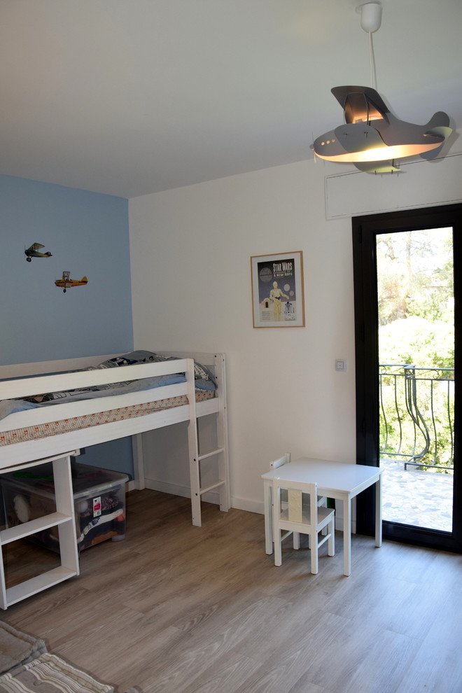 Aménagement d'une chambre d'enfant de 4 à 10 ans contemporaine de taille moyenne avec un mur bleu, un sol en vinyl et un sol marron.