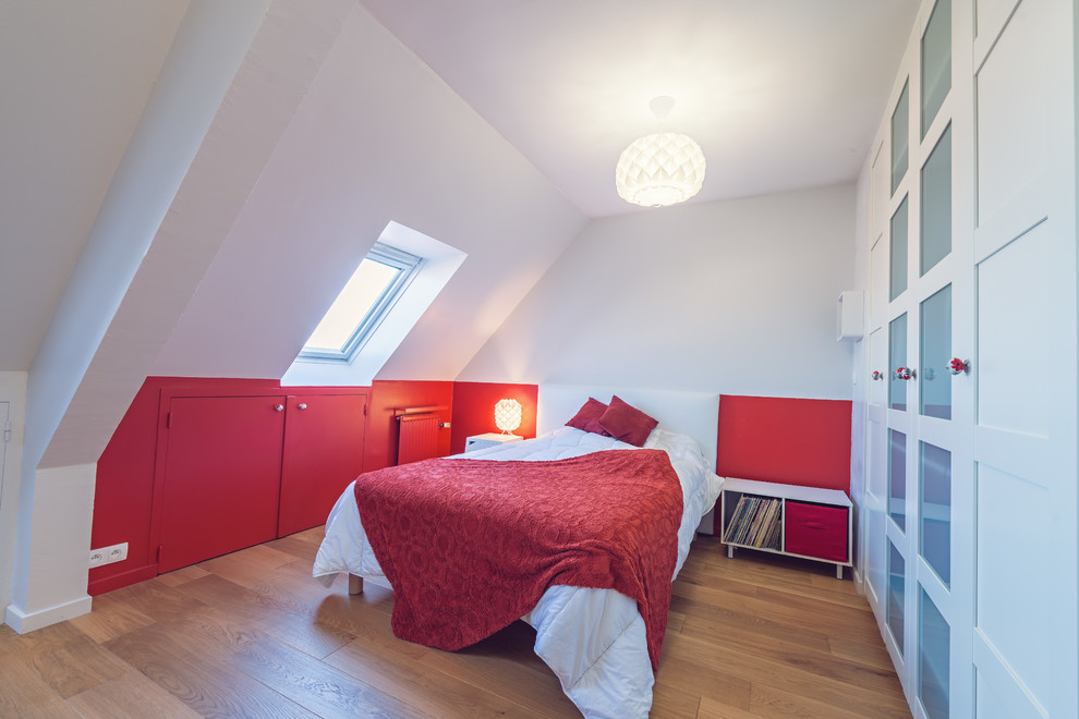 Ispirazione per una grande cameretta per bambini design con pareti rosse e parquet chiaro