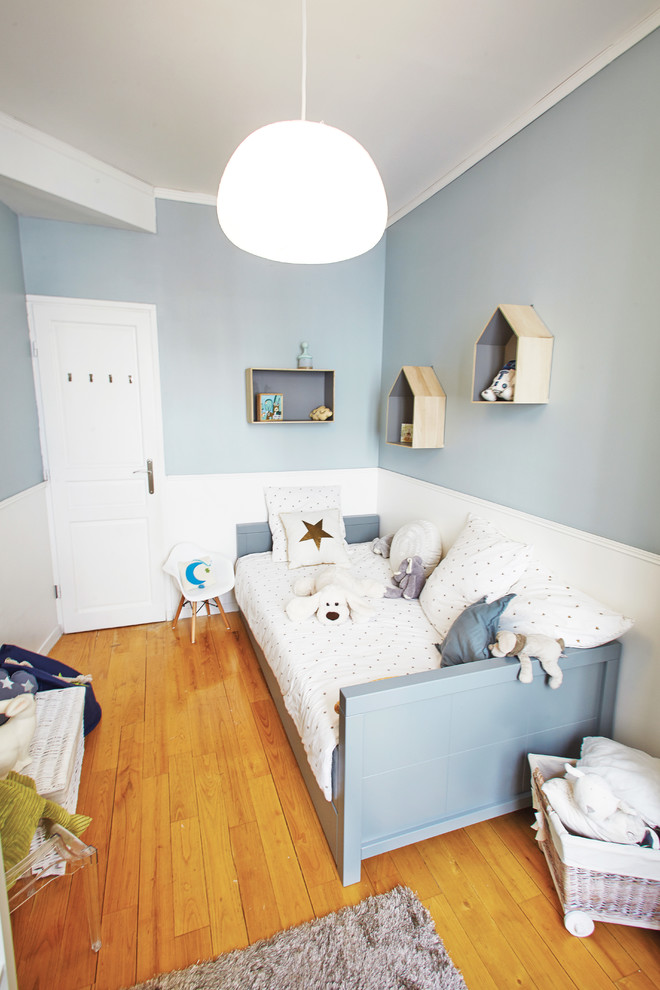 Imagen de dormitorio infantil de 4 a 10 años tradicional renovado de tamaño medio con paredes azules, suelo de madera clara y suelo marrón