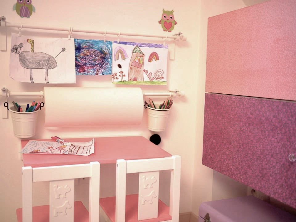 Immagine di una piccola cameretta per bambini da 1 a 3 anni shabby-chic style con pareti bianche, pavimento in laminato e pavimento beige