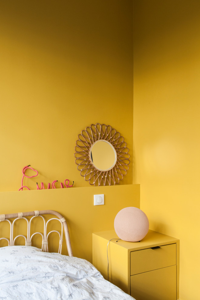 Exempel på ett mellanstort modernt flickrum kombinerat med sovrum och för 4-10-åringar, med gula väggar och ljust trägolv