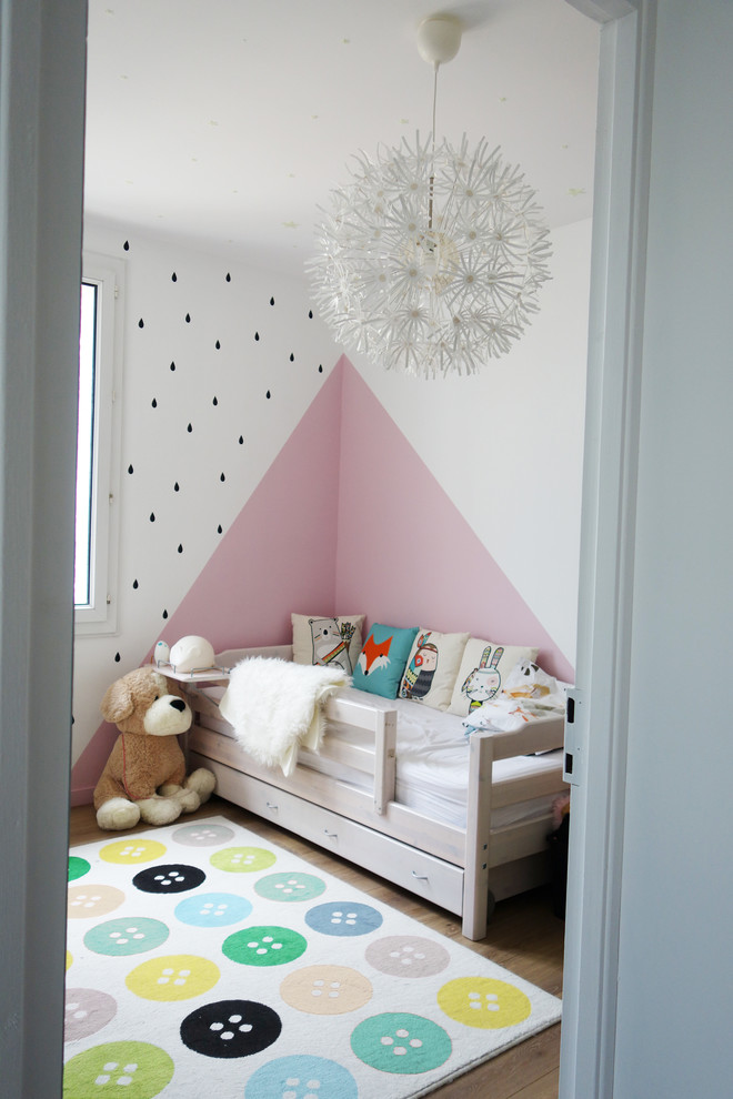Imagen de habitación de niña minimalista con paredes rosas y suelo marrón
