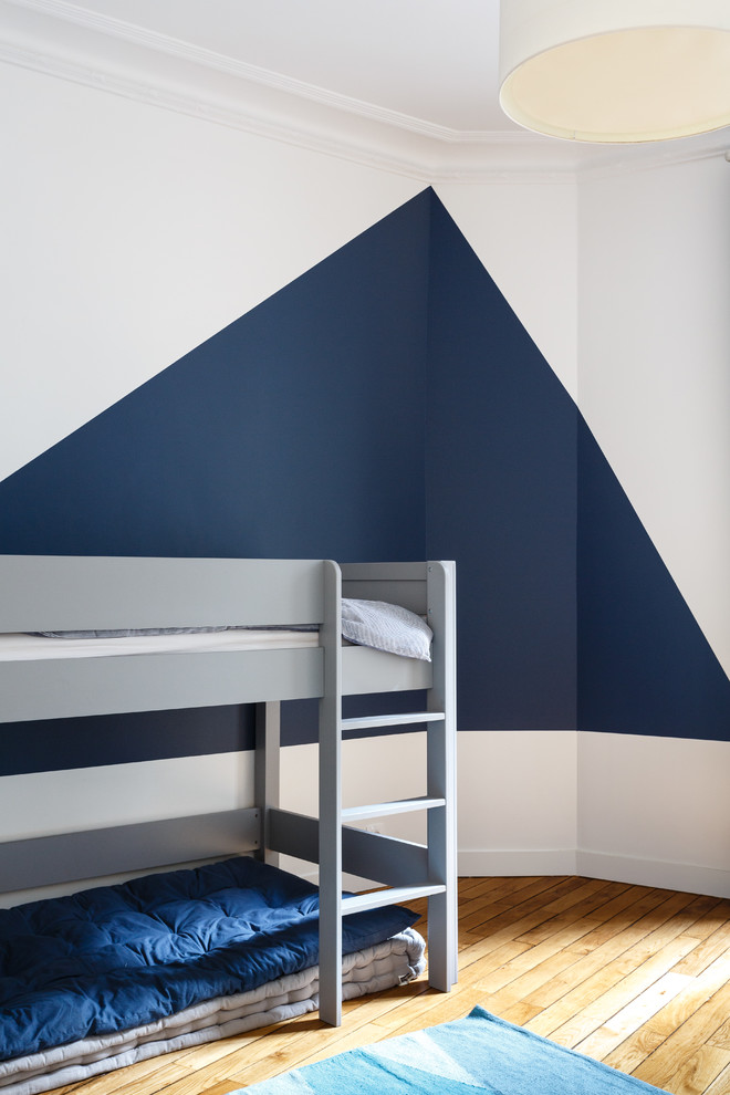Exemple d'une chambre d'enfant de 4 à 10 ans scandinave de taille moyenne avec un mur bleu, un sol en bois brun et un sol marron.