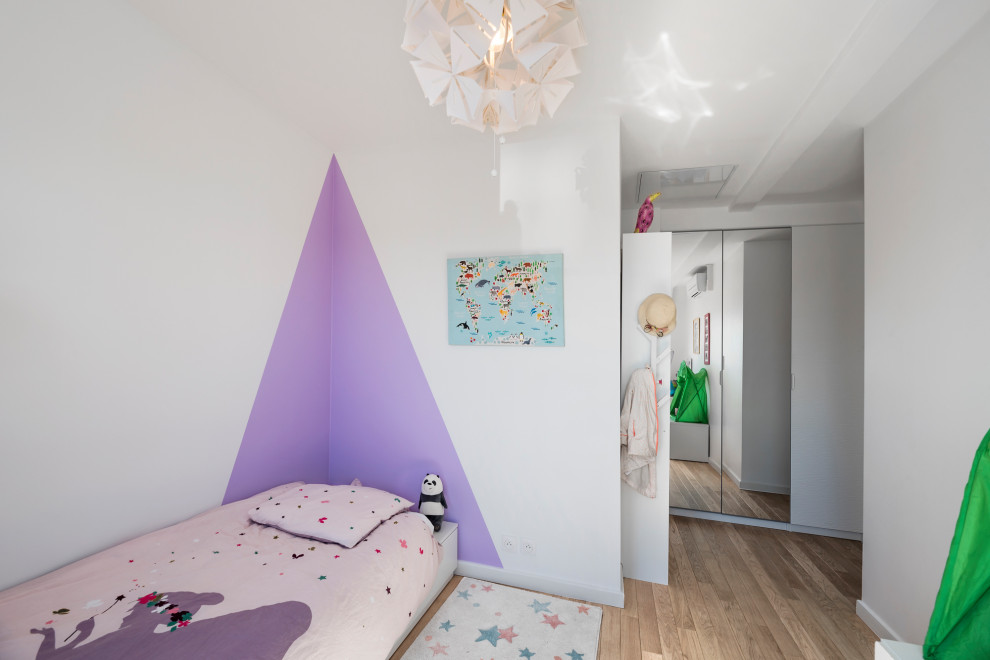 Idées déco pour une chambre d'enfant contemporaine avec un mur blanc, un sol en bois brun et un sol marron.