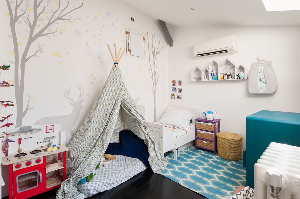 Inspiration for a medium sized bohemian children’s room for boys in Paris with white walls and black floors.