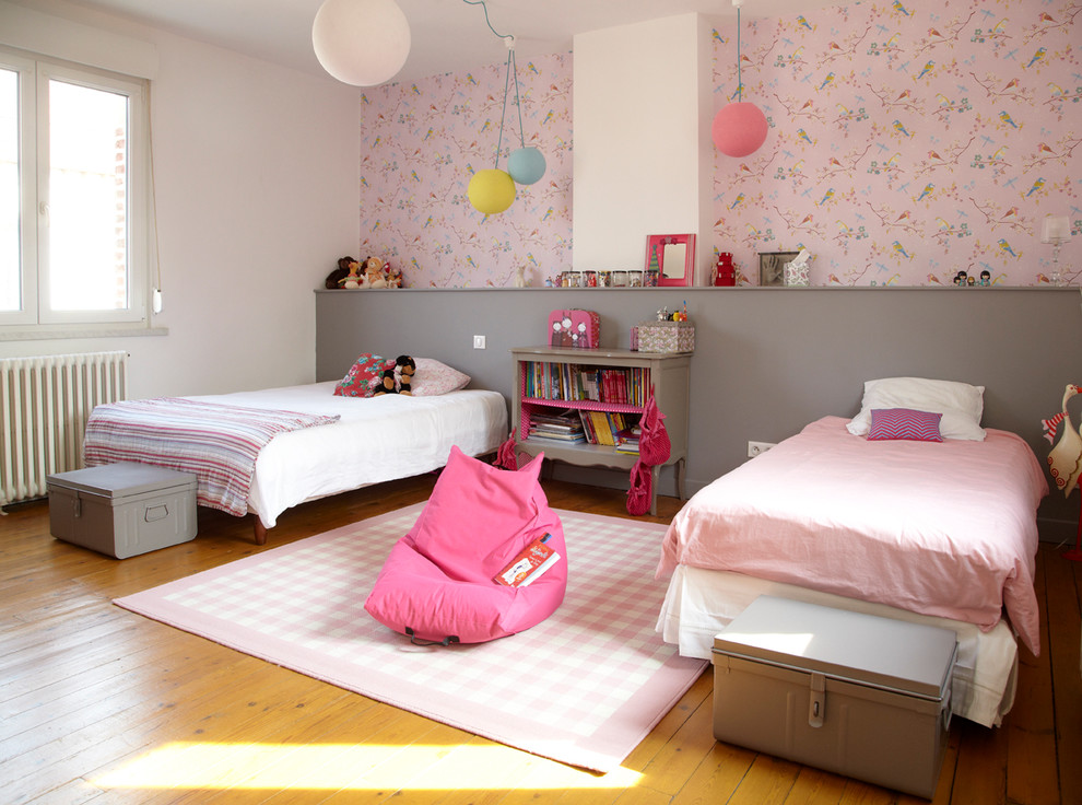 Aménagement d'une grande chambre d'enfant de 4 à 10 ans contemporaine avec parquet clair et un mur multicolore.
