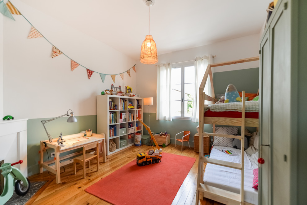Design ideas for a large contemporary gender neutral children’s room in Toulouse with green walls, dark hardwood flooring and brown floors.
