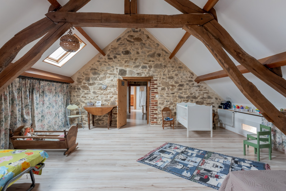 This is an example of a large farmhouse gender neutral toddler’s room in Dijon with white walls, laminate floors and white floors.