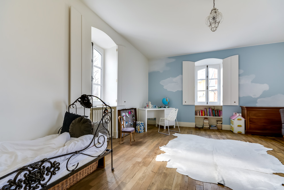 Foto di una grande cameretta per bambini da 4 a 10 anni tradizionale con pareti blu e pavimento in legno massello medio