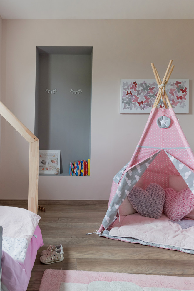 Modernes Mädchenzimmer mit Spielecke, beiger Wandfarbe, braunem Holzboden und beigem Boden in Lyon