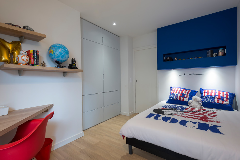 Immagine di una cameretta per bambini design di medie dimensioni con pareti blu, parquet chiaro e pavimento beige