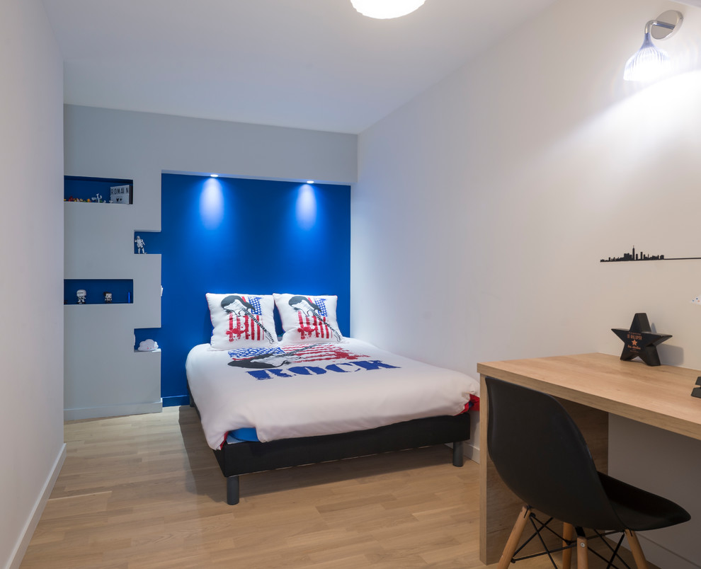 Cette image montre une chambre d'enfant design de taille moyenne avec un mur bleu, parquet clair et un sol beige.