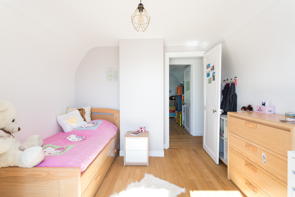 Diseño de dormitorio infantil de 4 a 10 años contemporáneo con paredes blancas, suelo de madera clara y suelo beige