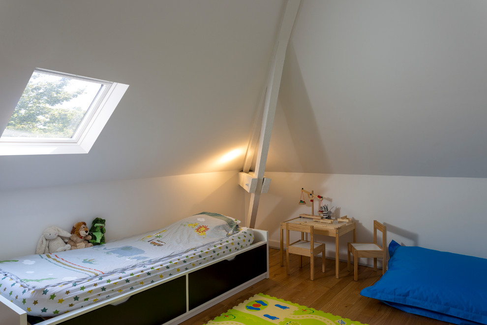Modern inredning av ett litet pojkrum kombinerat med sovrum och för 4-10-åringar, med vita väggar, ljust trägolv och beiget golv
