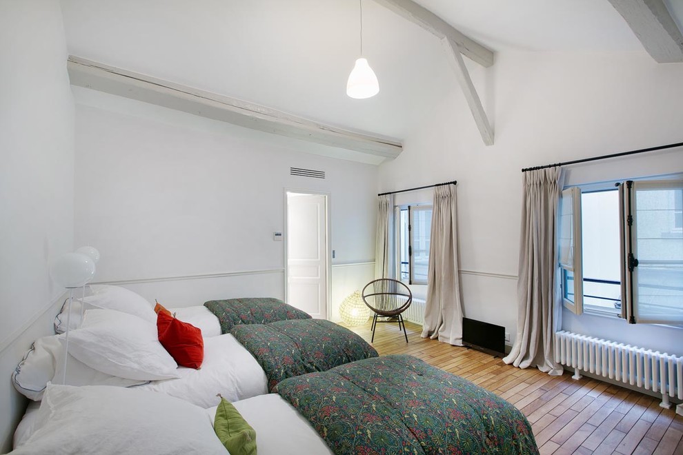 Imagen de dormitorio ecléctico grande con paredes blancas y suelo de madera en tonos medios