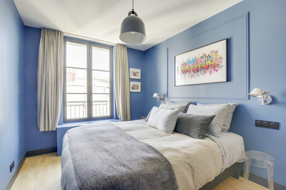 Ispirazione per una piccola cameretta per bambini design con pareti blu, parquet chiaro e pavimento beige