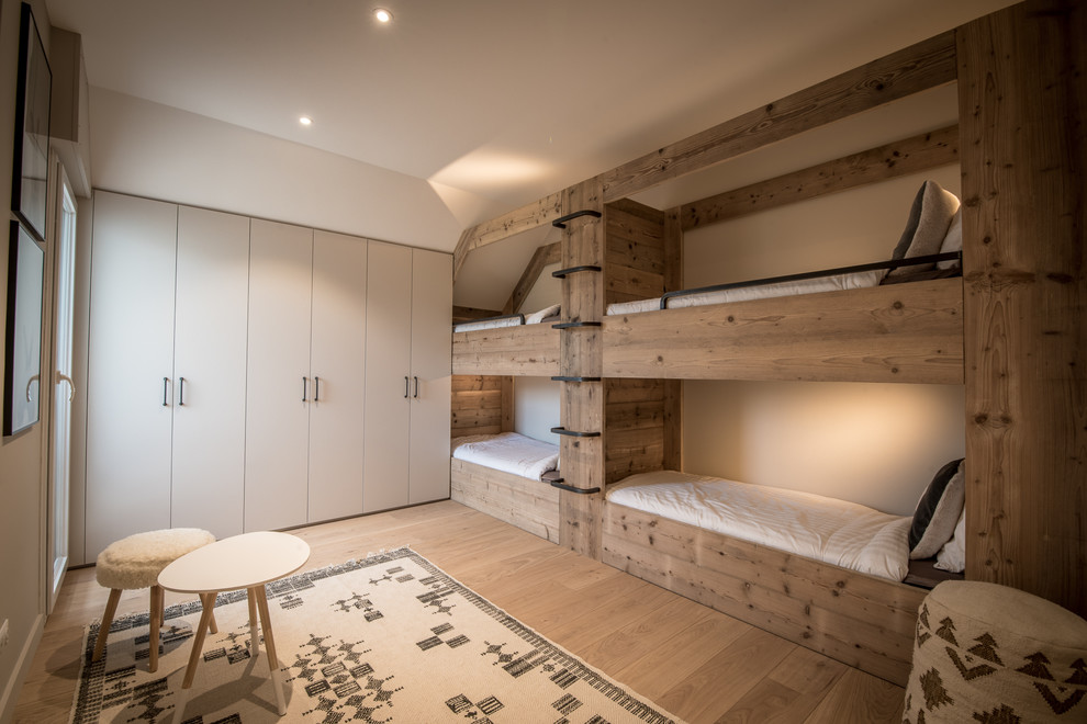 Imagen de dormitorio infantil de 4 a 10 años rural de tamaño medio con paredes beige y suelo de madera clara