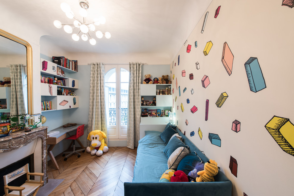 Example of a mid-sized transitional boy medium tone wood floor and brown floor kids' room design in Paris with blue walls