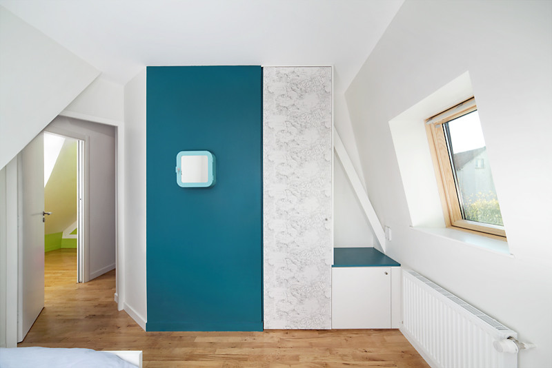 Inredning av ett modernt litet barnrum kombinerat med sovrum, med blå väggar och ljust trägolv