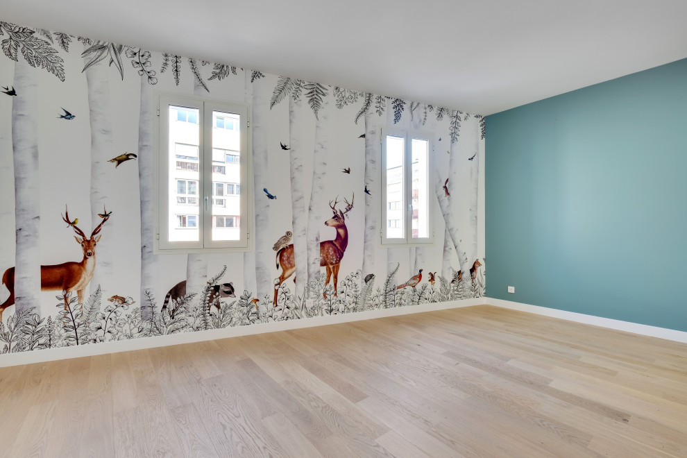 Ispirazione per una grande cameretta per bambini da 4 a 10 anni minimalista con pareti bianche, pavimento in legno massello medio, pavimento beige e carta da parati