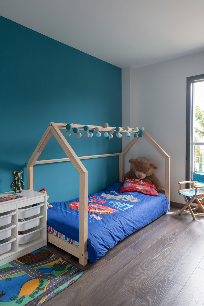 Foto på ett funkis pojkrum kombinerat med sovrum och för 4-10-åringar, med vita väggar, mörkt trägolv och brunt golv