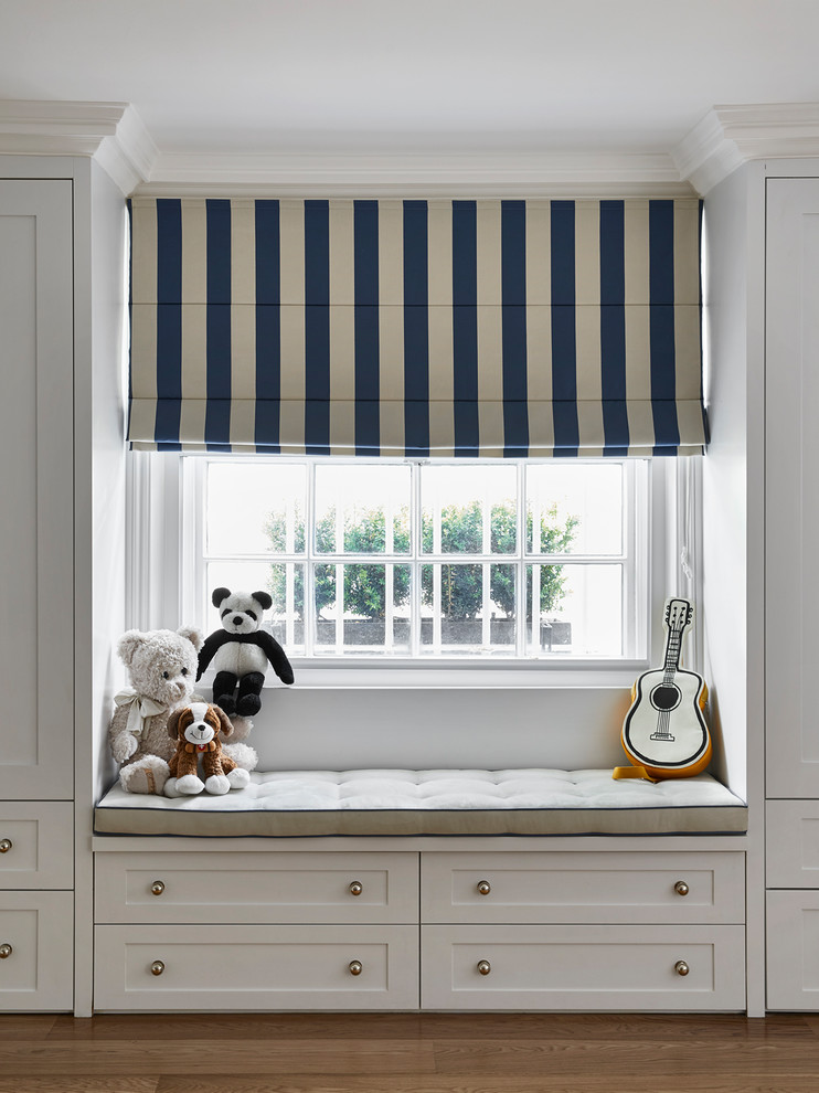 Design ideas for a large classic children’s room for boys in London with white walls and light hardwood flooring.