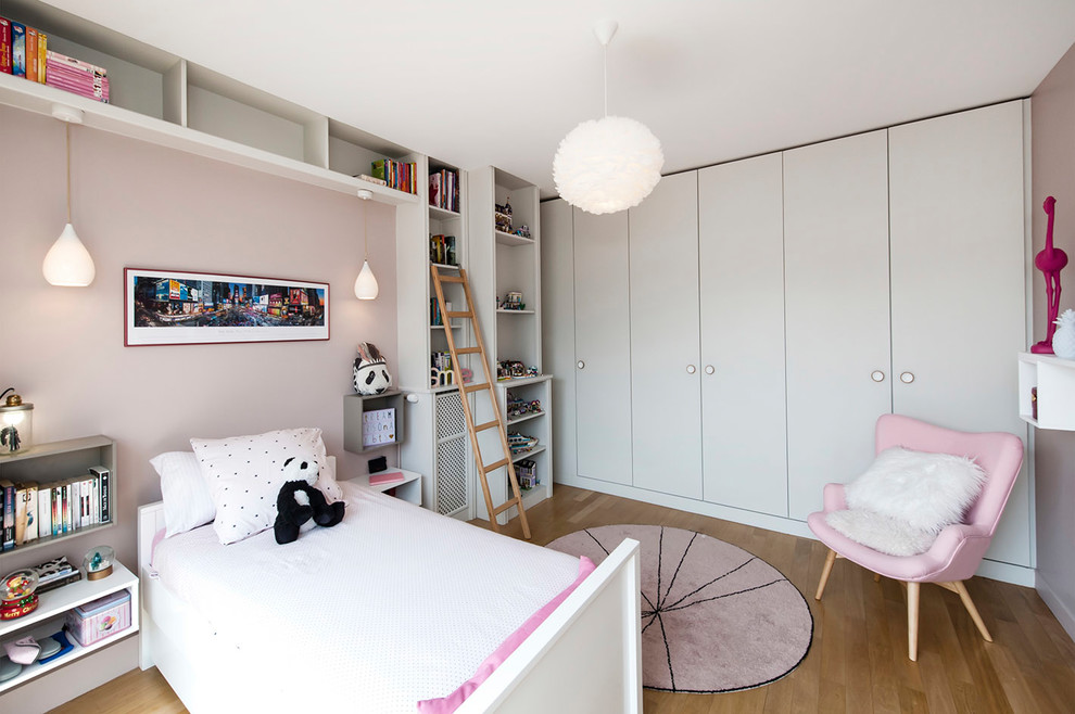 Foto di una cameretta per bambini da 4 a 10 anni contemporanea di medie dimensioni con pareti rosa, parquet chiaro e pavimento beige
