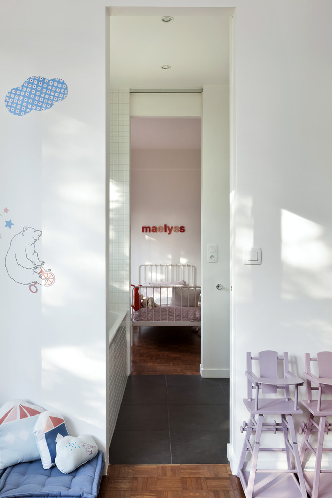 На фото: детская среднего размера в современном стиле с спальным местом, белыми стенами и темным паркетным полом для ребенка от 4 до 10 лет, девочки с