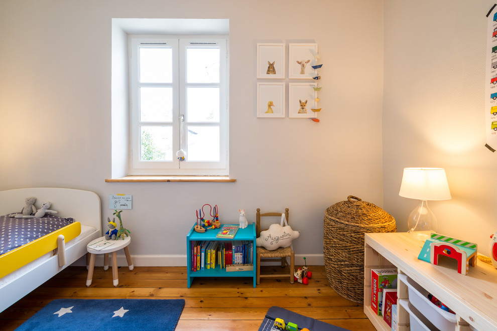 Inspiration for a medium sized scandi toddler’s room for boys in Lyon with white walls and medium hardwood flooring.