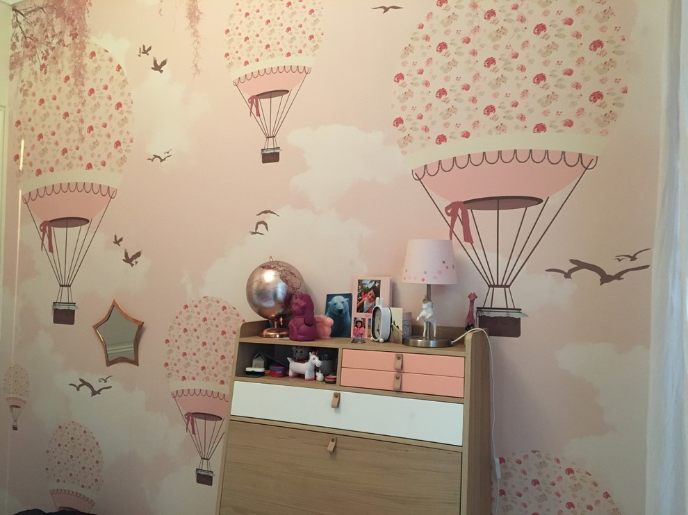 Cette photo montre une chambre d'enfant de 4 à 10 ans tendance de taille moyenne avec un mur rose, parquet foncé et un sol marron.