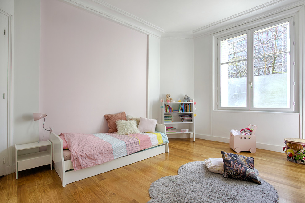 Idée de décoration pour une grande chambre d'enfant de 4 à 10 ans tradition avec un mur blanc et parquet clair.