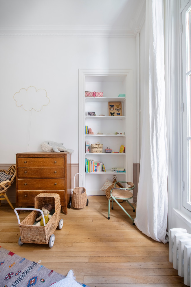 Idee per una cameretta per bambini da 4 a 10 anni shabby-chic style di medie dimensioni con pareti bianche, parquet chiaro e pavimento beige