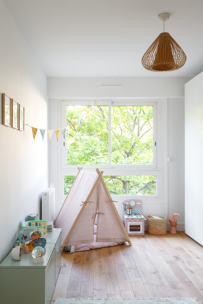 На фото: детская среднего размера в скандинавском стиле с спальным местом, белыми стенами, светлым паркетным полом и бежевым полом для ребенка от 4 до 10 лет, девочки