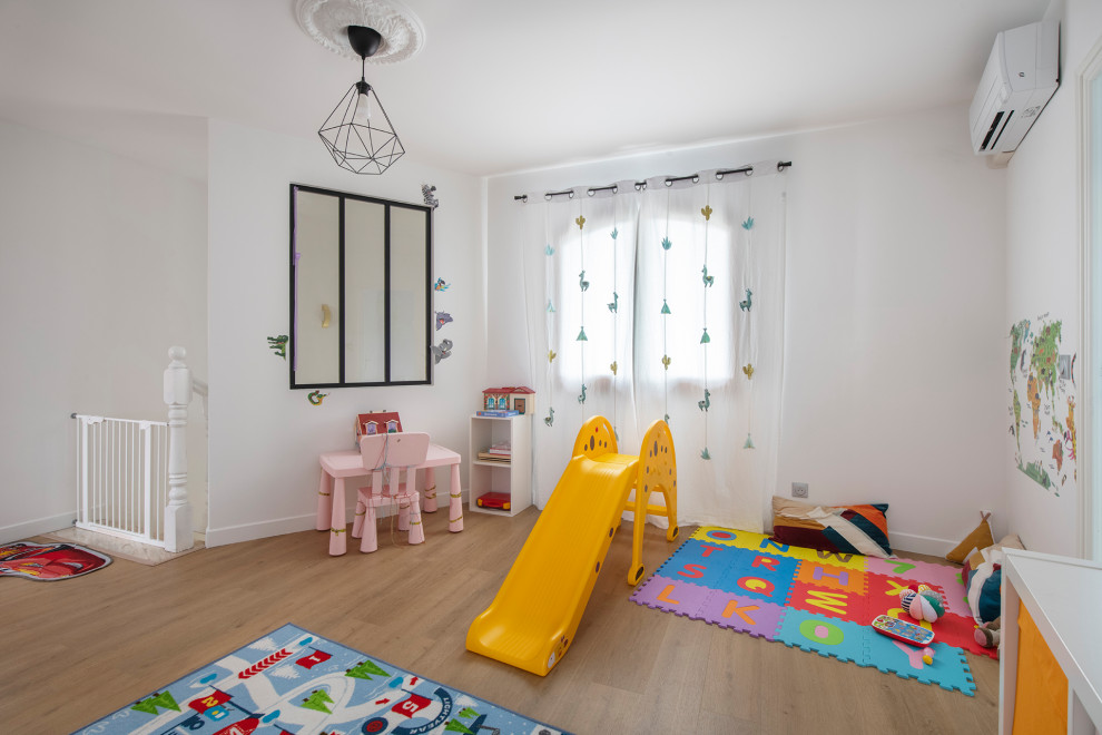Cette image montre une grande chambre d'enfant de 4 à 10 ans minimaliste avec un mur blanc, sol en stratifié et un sol beige.