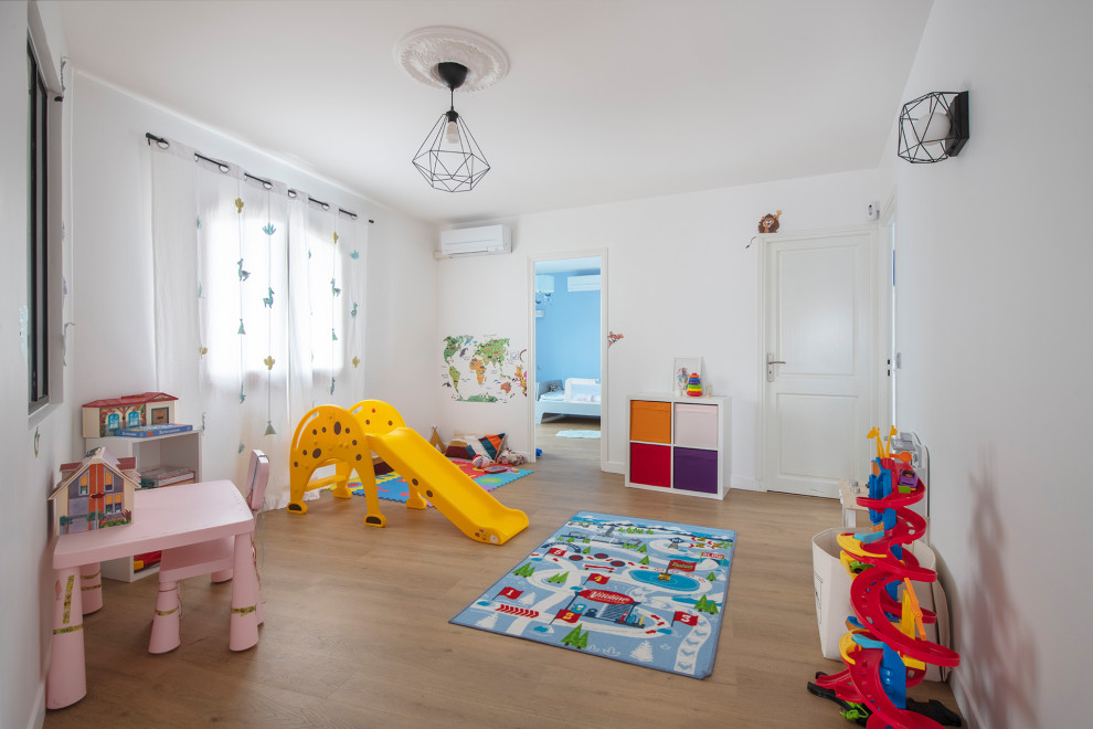 Ispirazione per una grande cameretta per bambini da 4 a 10 anni minimalista con pareti bianche, pavimento in laminato e pavimento beige