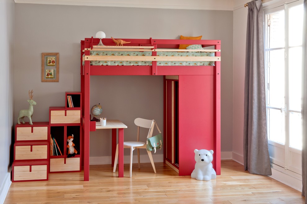 Example of a small trendy gender-neutral light wood floor kids' room design in Paris with multicolored walls
