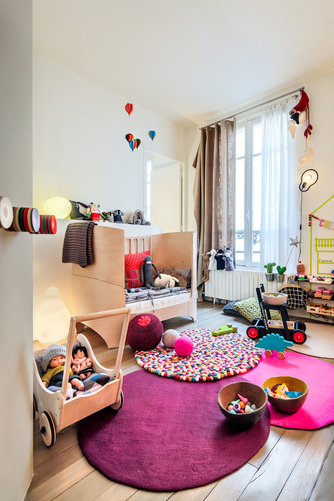 Источник вдохновения для домашнего уюта: нейтральная детская среднего размера в современном стиле с спальным местом, белыми стенами и паркетным полом среднего тона для ребенка от 1 до 3 лет