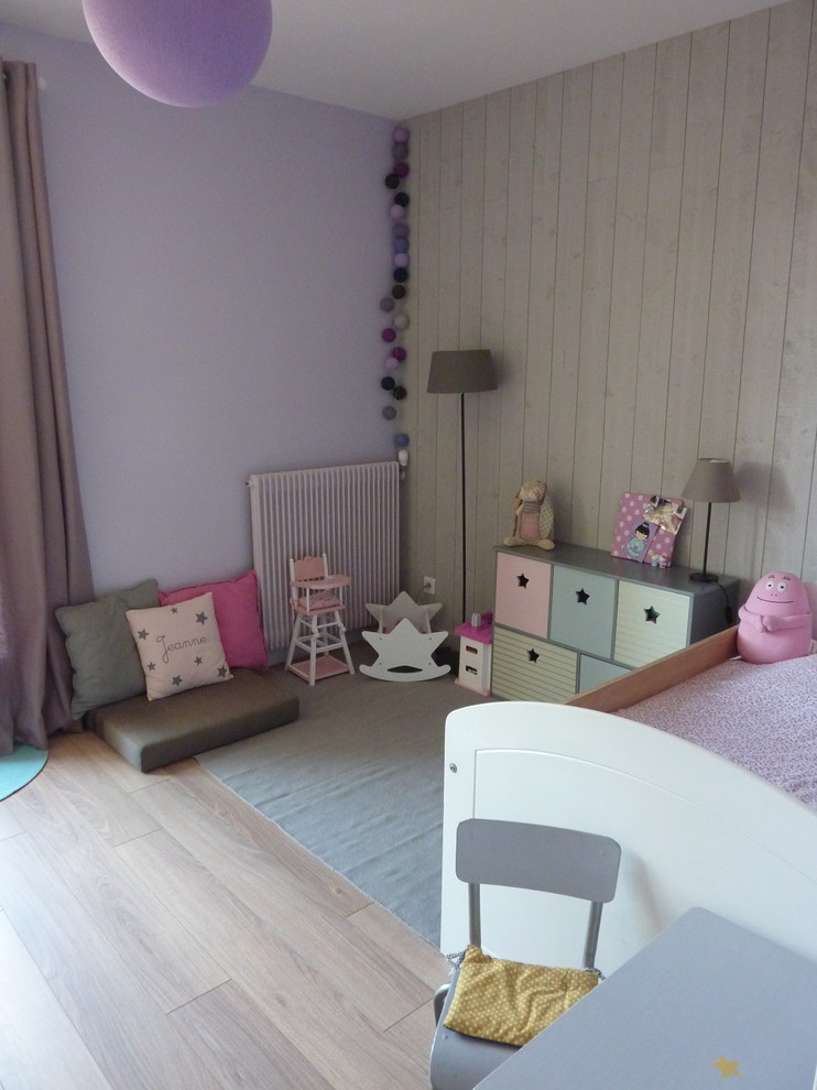 Immagine di una cameretta per bambini da 4 a 10 anni nordica di medie dimensioni con pareti viola e parquet chiaro