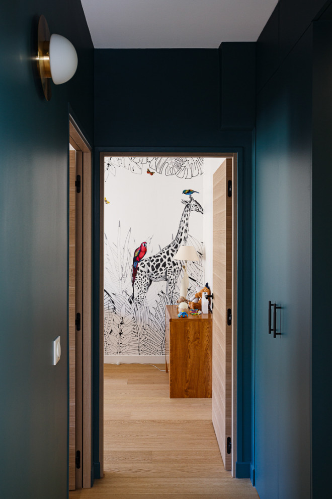 Mid-sized trendy gender-neutral light wood floor, beige floor and wallpaper kids' room photo in Paris with multicolored walls