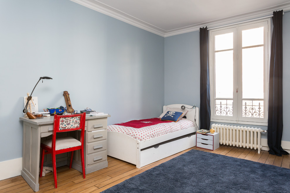 Idées déco pour une chambre d'enfant de 4 à 10 ans contemporaine de taille moyenne avec un mur bleu, un sol beige et un sol en bois brun.