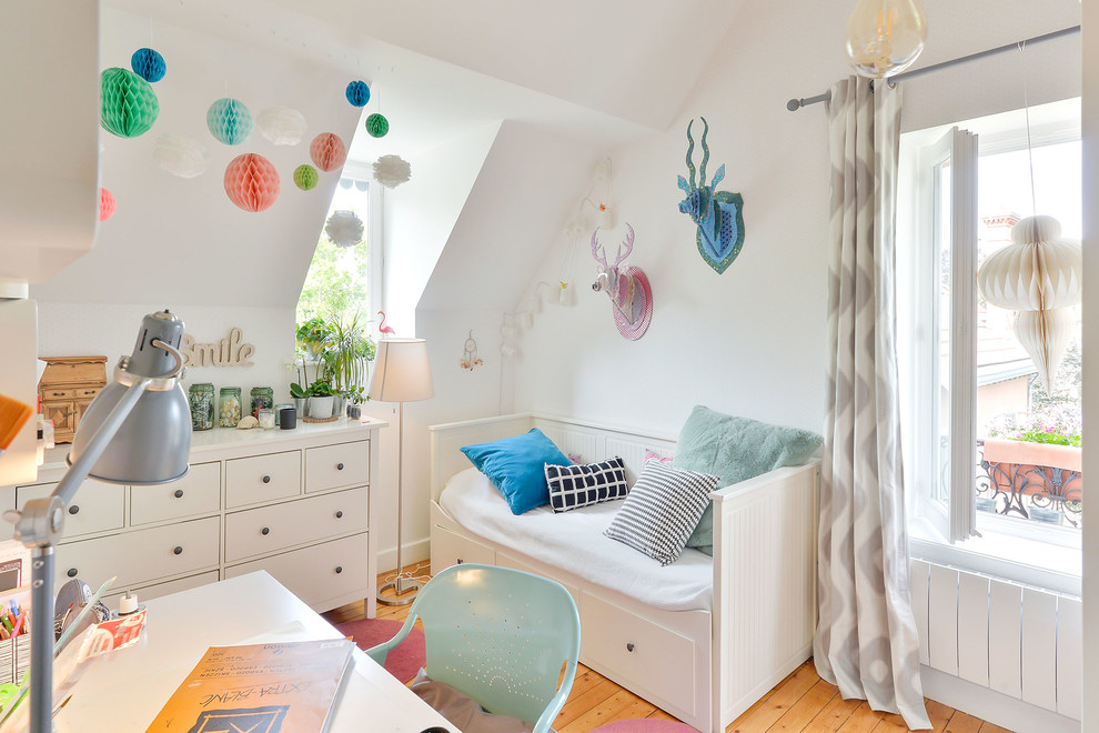 Inspiration for a scandi kids' study space for girls in Lyon with white walls and medium hardwood flooring.